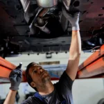 auto-repairman-examining-undercarriage-car-workshop_637285-7632.jpg